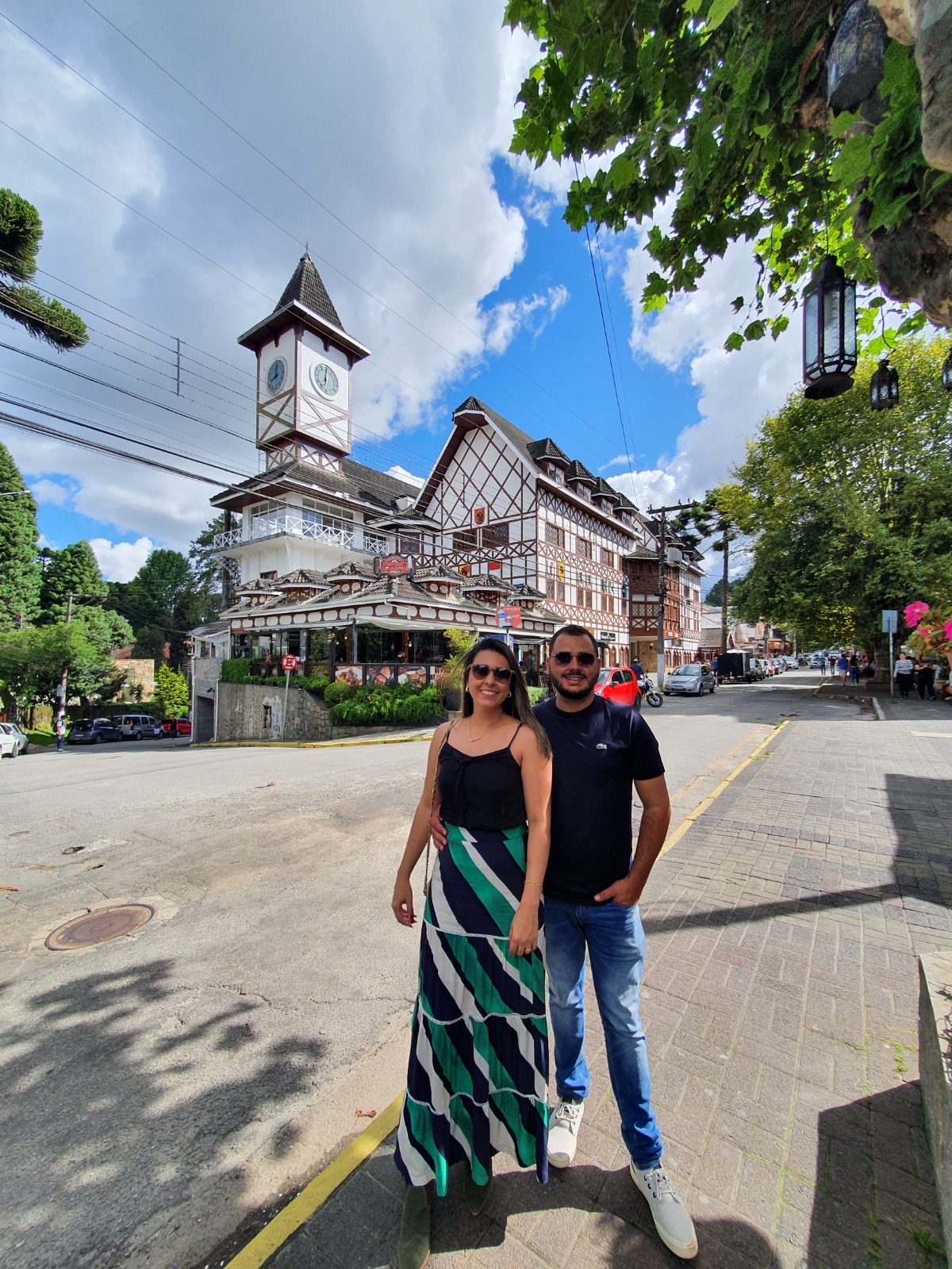 Karen e Vitor em frente ao prédio com torre do relógio, em Campos do Jordão